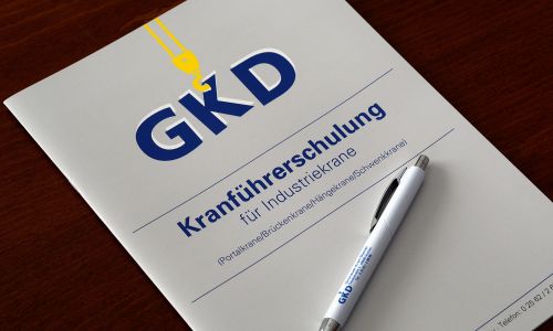 Schulungsunterlagen der GKD zur Kranführerschulung mit Kugelschreiber auf einem Tisch.